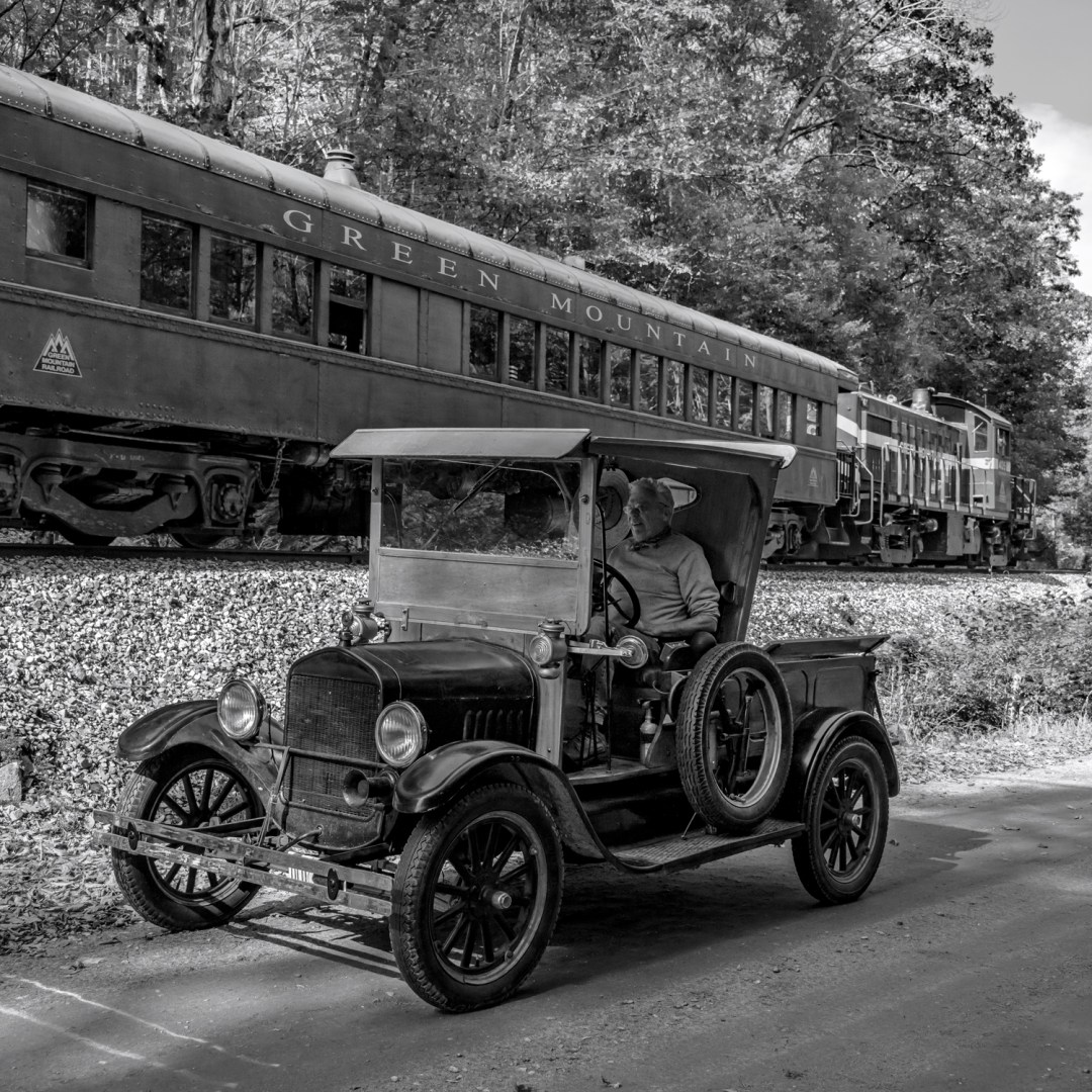 a train is parked on the side of a dirt road