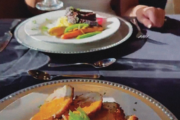 a person sitting at a table with a plate of food