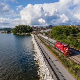 a train traveling down train tracks next to a river