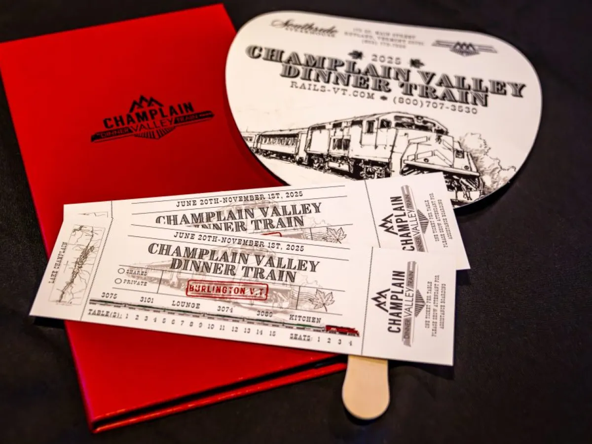 Champlain Valley Dinner Train tickets and brochure on a black surface.